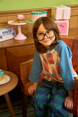 The Bottle Tee from Momohanipopo. Raglan-style t-shirt with contrast sleeves featuring a playful red bottle print.