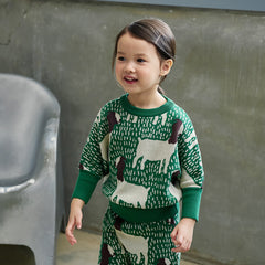 The Goat Top from Momohanipopo. Green knitted sweater with cream and brown animal pattern, ribbed crew neck.