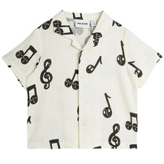 The Note Muslin Shirt from Mini Rodini. Short sleeve muslin shirt with a cuban collar and button closure.