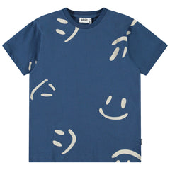 The Riley Tee from Molo. Playful navy T-shirt adorned with oversized cream-colored smiley faces