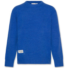 The Junior C Neck Elbow Sweater from AO76. Blue cozy knit sweater with a label.