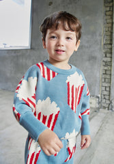 The Popcorn Top from Momohanipopo. Knitted sweater in a soft sky-blue color featuring a playful popcorn bucket pattern.
