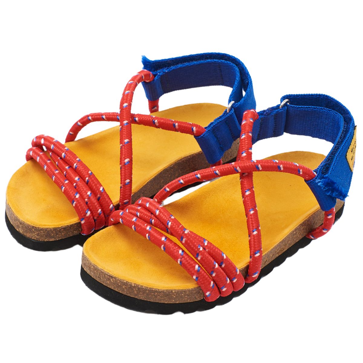 Arandano Sandals by Maison Mangostan feature a red rope upper and easy-to-fasten blue velcro closure at the ankle.