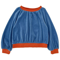 The Velvet Sweater from Long Live the Queen features a blue body with contrasting red ribbed cuffs and hem.