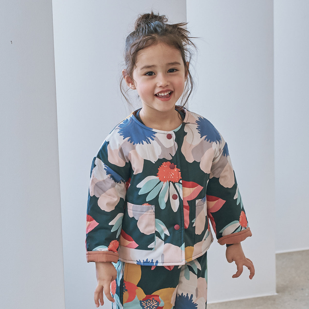 Momohanipopo Multiflower Padded Reversible Jacket featuring a colorful floral print, collarless neck, and snap buttons.