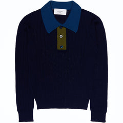 The Wool Seamless Polo Shirt from Paade Mode. Navy sweater with a blue collar and green button placket.