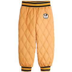 The Ritzratz Quilted Outerwear Pants from Mini Rodini. Quilted light brown pants with an embroidered patch logo.
