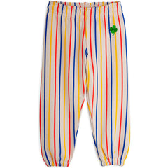 The Clover Sweatpants from Mini Rodini. Colorful striped sweatpants with a green clover patch on a white background.