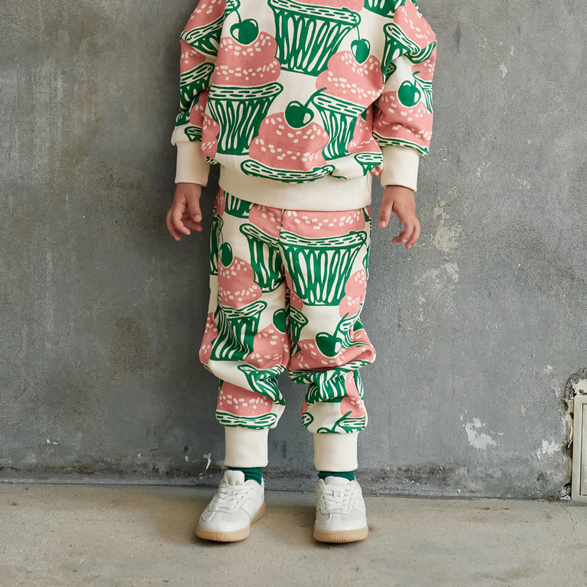 The Cupcake Sweatpants from Momohanipopo. Cream jogger-style pants with an all-over cupcake and cherry print.