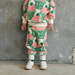 The Cupcake Sweatpants from Momohanipopo. Cream jogger-style pants with an all-over cupcake and cherry print.