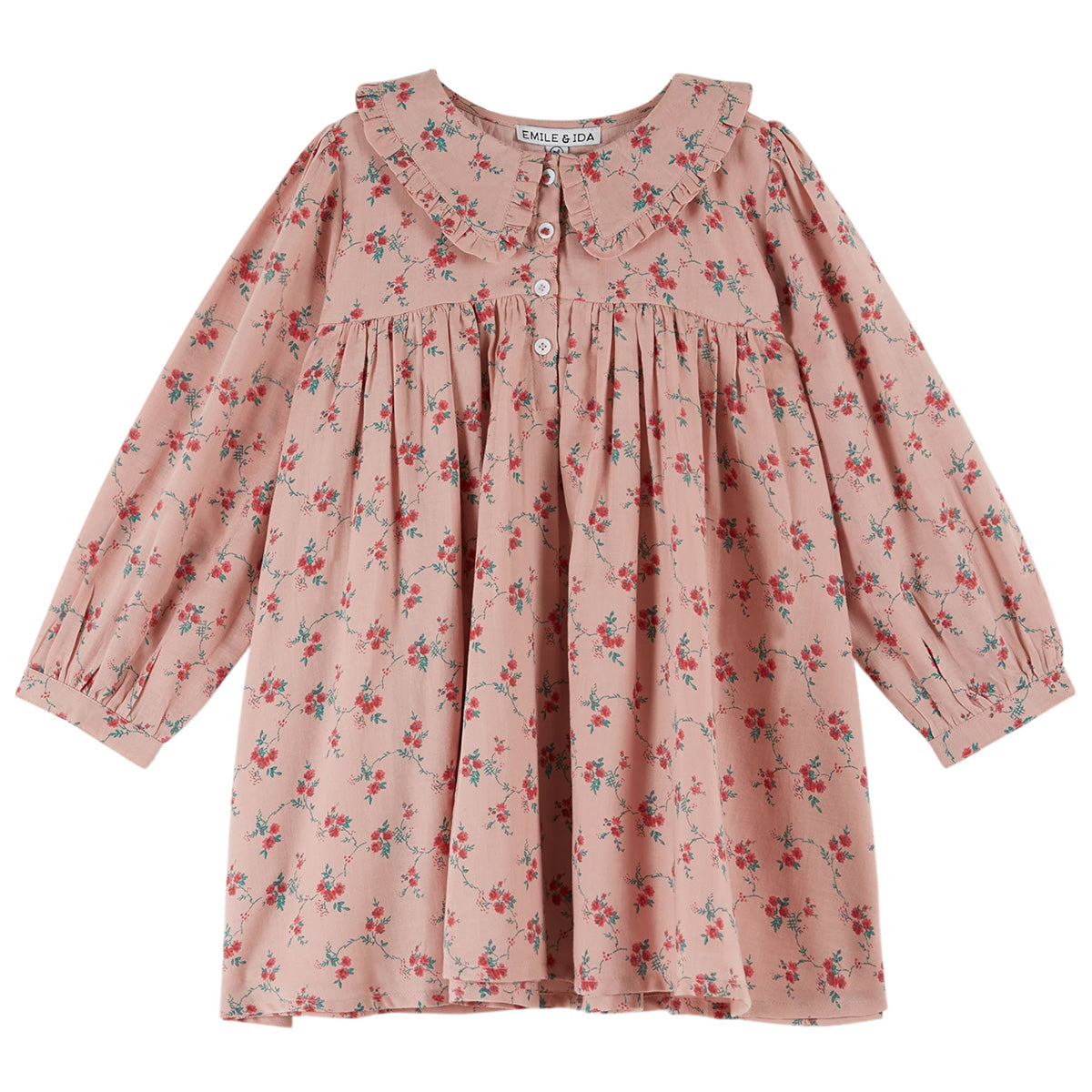 The Spinning Dress from Emile et Ida. Cotton dress adorned with floral bouquets on a pink background.