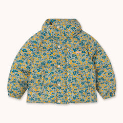 A hooded puffer jacket by designer Tiny Cottons with a dense abstract floral pattern in teal, yellow, and off-white, featuring a button-up front and a small 'TINY' logo on the chest.