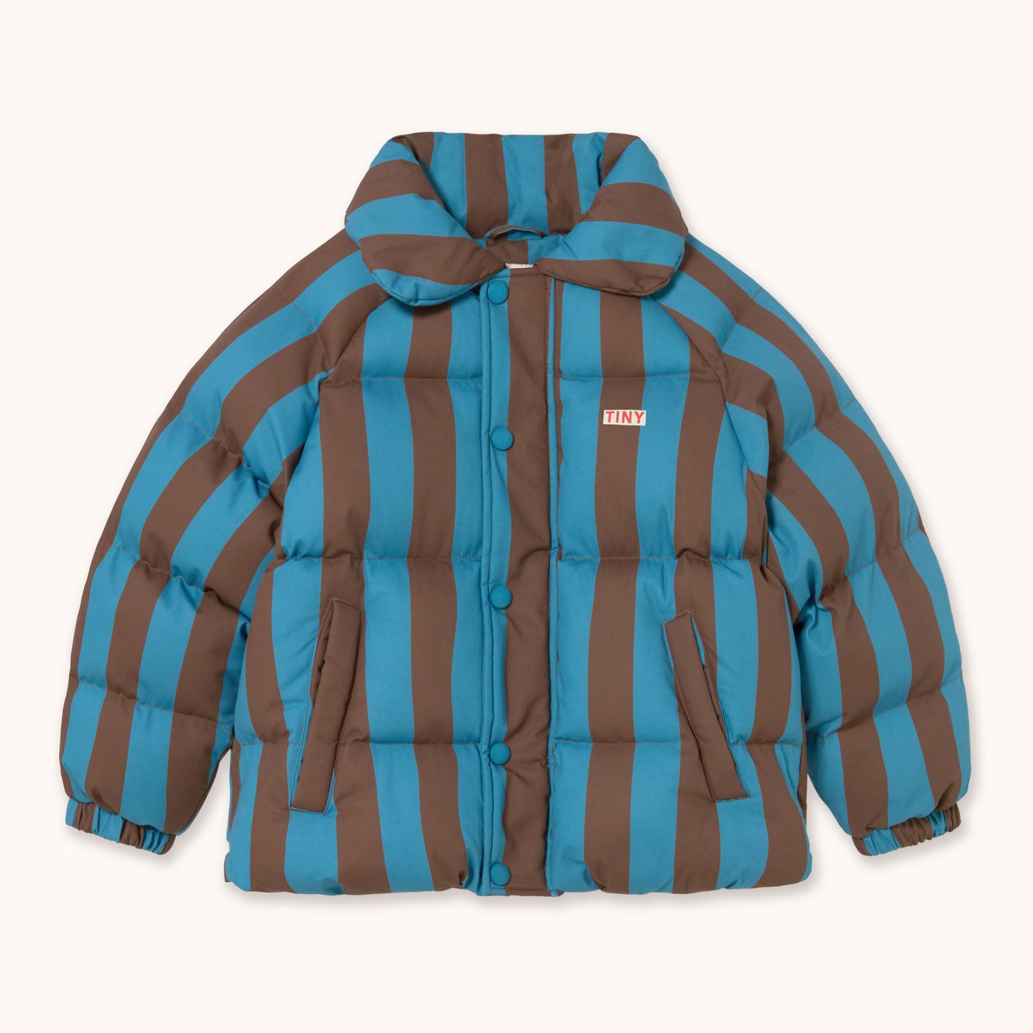A puffer jacket by designer Tiny Cottons with bold vertical brown and teal-blue stripes, featuring a button-up front, a soft collar, and zippered hand pockets, shown flat on a light cream background.