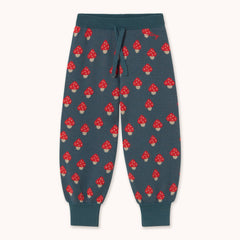 A pair of dark teal sweatpants by designer Tiny Cottons with an all-over red and white mushroom print, featuring a matching dark teal drawstring waist and ribbed cuffs.