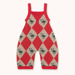 A baby knit romper by designer Tiny Cottons in red and beige argyle pattern with small green and black bird motifs, featuring a three-button henley neckline and adjustable shoulder straps, shown flat on a light cream background.