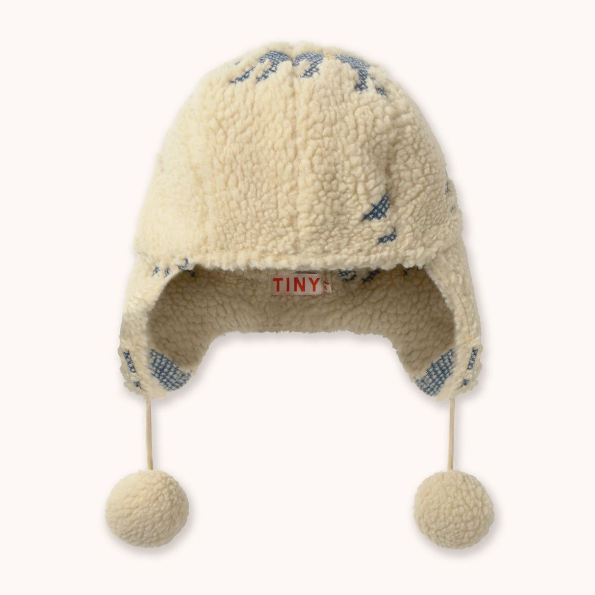 Cream colored children's hat  with earflaps and pompoms by designer Tiny Cottons.