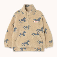 A beige sherpa fleece sweatshirt by designer Tiny Cottons, with an all-over blue horse print and a small white 'TINY' brand patch on the chest, displayed flat against a light cream background.