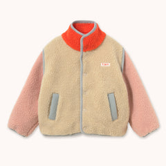 A children's sherpa fleece jacket by designer Tiny Cottons with a beige body, pink sleeves, a bright orange collar, and gray trim, featuring a small 'TINY' brand patch on the chest.
