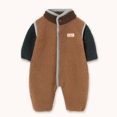 A baby fleece sleeper by designer Tiny Cottons with a brown sherpa vest body, dark teal long sleeves, and a gray trim, featuring a small 'TINY' brand patch on the chest.