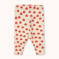 A pair of cream-colored ribbed leggings for toddlers by designer Tiny Cottons, featuring an all-over red and white mushroom print, laid flat against a light off-white background.