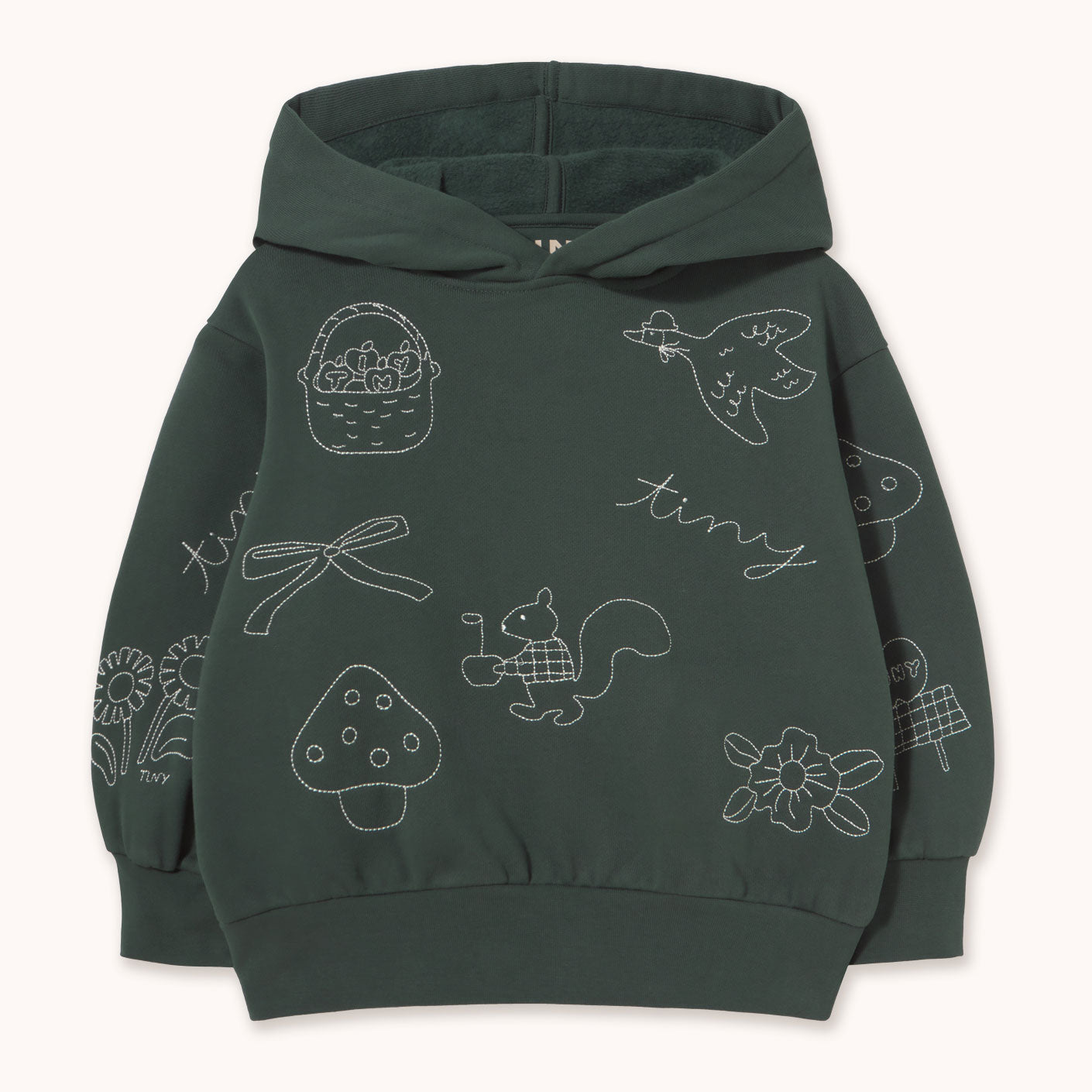 A dark gray children's pullover hoodie with white line-art illustrations of a bird, basket, bow, mushroom, squirrel, flowers, and the word 'tiny' printed on the front, by designer Tiny Cottons, shown against a light cream background.