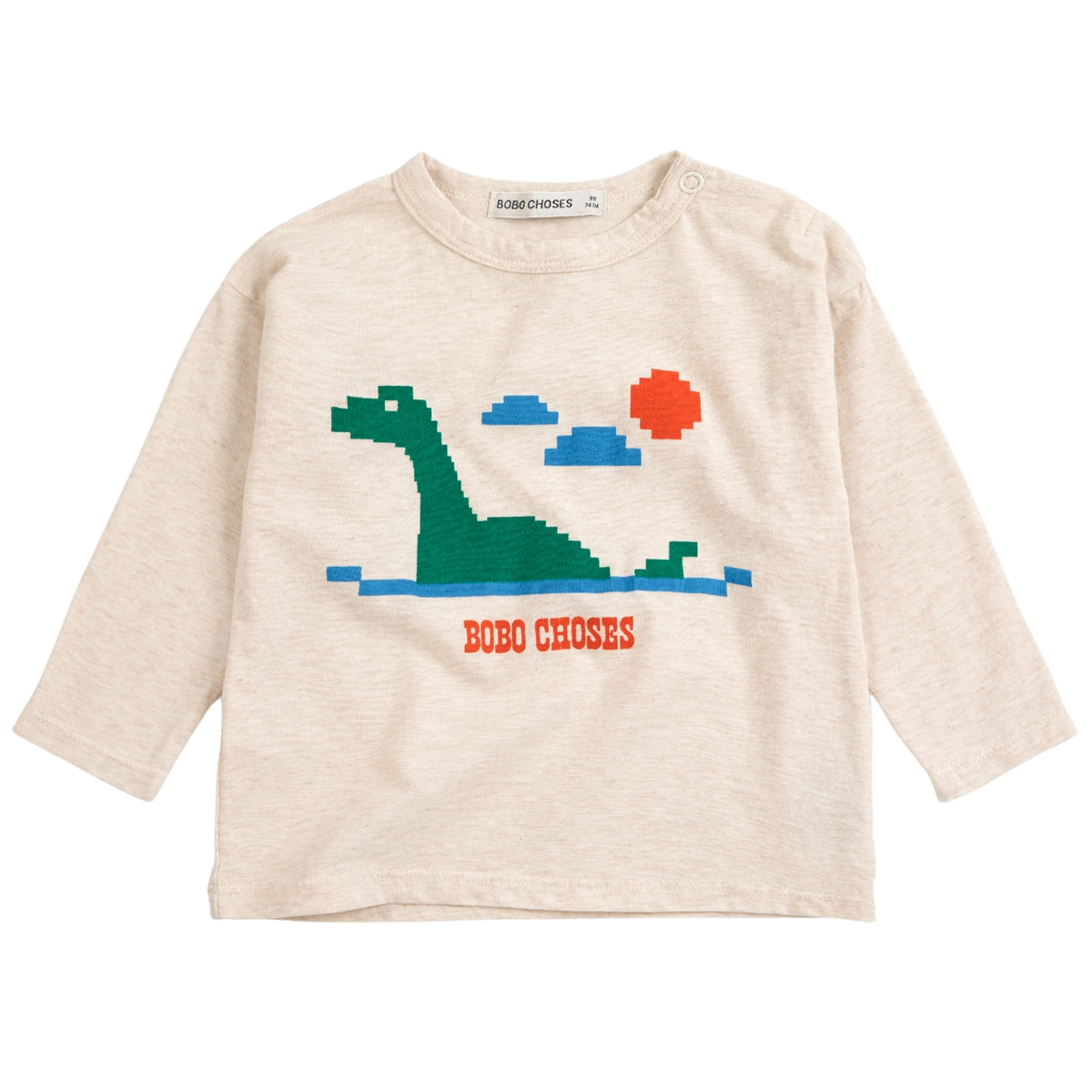 The Lake Monster Tee from Bobo Choses in heather beige featuring a pixelated green lake monster graphic and shoulder snaps.
