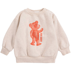 The Softpaw Monster Sweatshirt from Bobo Choses in heathered oatmeal with an orange teddy bear graphic and shoulder snaps.
