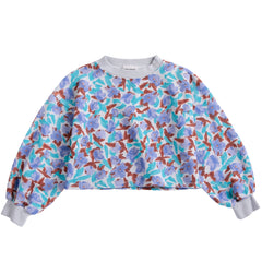 The Watercolor All Over Cropped Sweatshirt featuring a purple and turquoise floral print with ribbed cuffs and collar.
