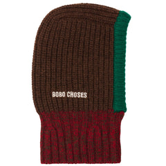 The Bobo Choses Knitted Balaclava in a brown, green, and burgundy ribbed knit with an embroidered white logo.