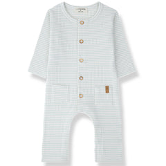 The Cambrils Jumpsuit from 1+ in the Family, a soft baby one-piece with a check pattern, front buttons, and two small front pockets.