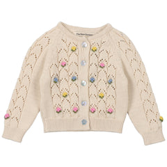 The Canea Baby Cardigan from The New Society. Cardigan with structure and flower details. It has a wooden button opening.
