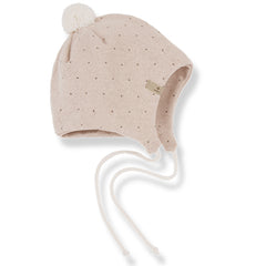 The Carlota Beanie from 1+ in the Family. Soft knit baby bonnet with subtle dotted pattern, pom-pom detail, and tie strings.