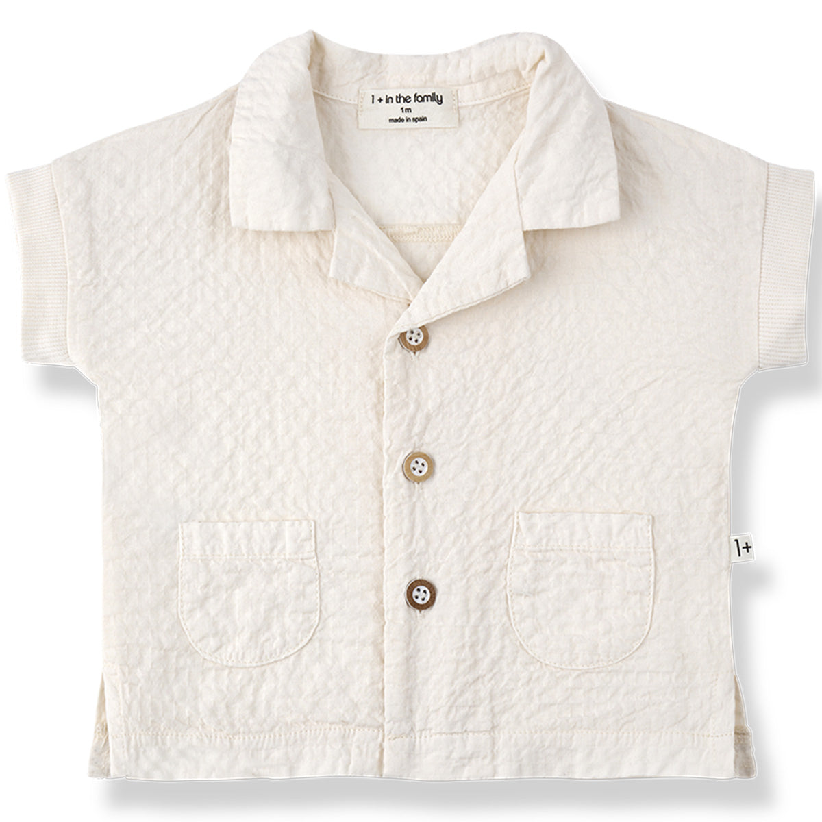The Corinto Shirt from 1+ in the Family, a textured baby shirt with a collar, front buttons, and two patch pockets.