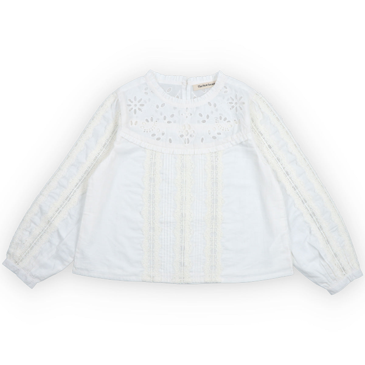 The Dahlia Blouse from The New Society. White blouse with lace details on a white background.