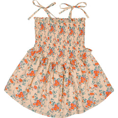 The Eden Cotton Bouquet Dress from Louis Louise in nude-orange floral cotton with smocked bodice and tie straps.