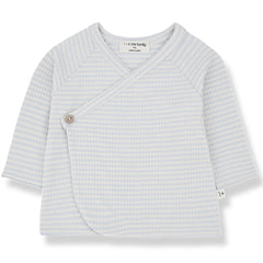 The Idara Shirt from 1+ in the Family. A charming baby wrap top featuring a crossover front with a button closure.