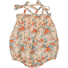 The Ava Cotton Bouquet Overall from Louis Louise floral baby romper with smocked bodice and tie straps.
