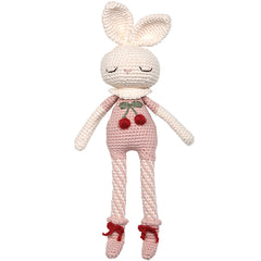 The Britney Bunny Cherry Blossom Doll from Patti Oslo. Crocheted toy rabbit with pink outfit and red accents on a white background.