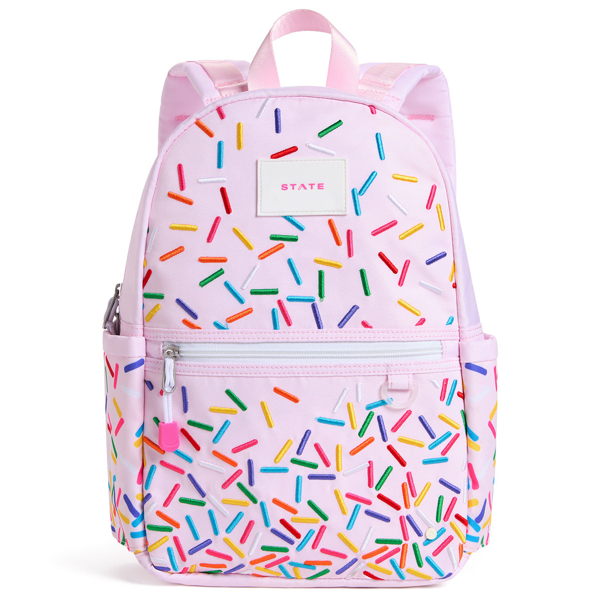 State Bags Kane Mini Backpack in light pink with sprinkle print, front zip pocket, zipper pull, and logo patch.