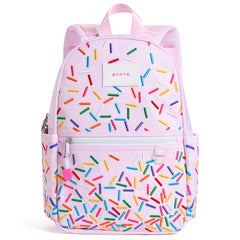 State Bags Kane Mini Backpack in light pink with sprinkle print, front zip pocket, zipper pull, and logo patch.