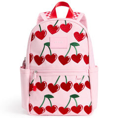 State Bags Kane Mini Backpack in pink with cherry print, front zip pocket, side pockets, top handle, and logo patch