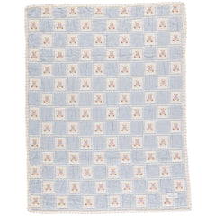 The Teddy Blanket from Bebe Organic featuring a knitted patchwork design with a signature bear motif and lace border trim.