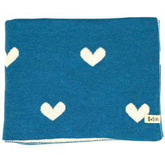 The Moon Phases Blanket from Bayiri. Blue blanket with white heart patterns and a brand label on a white background.