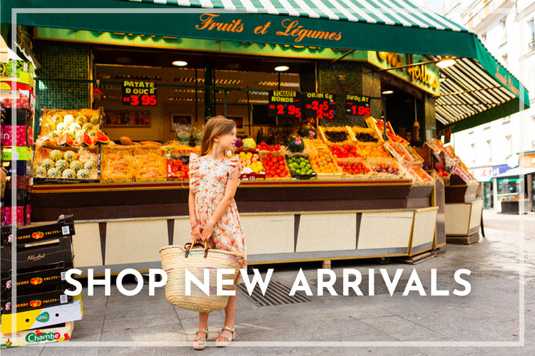Girl wearing designer Louis Louise dress shopping at a market with 'Fruits et Légumes' sign and 'Shop New Arrivals' text overlay.