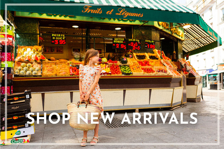 Girl wearing designer Louis Louise dress shopping at a market with 'Fruits et Légumes' sign and 'Shop New Arrivals' text overlay.