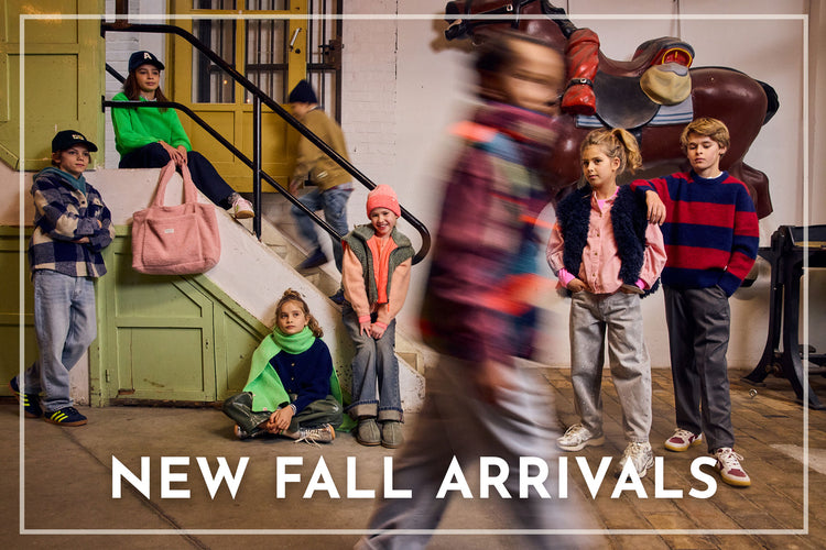 A group of children wearing colorful fall fashion clothing pose on the steps of a building, with a blurred figure walking in the foreground. Large white text at the bottom reads 'NEW FALL ARRIVALS'.
