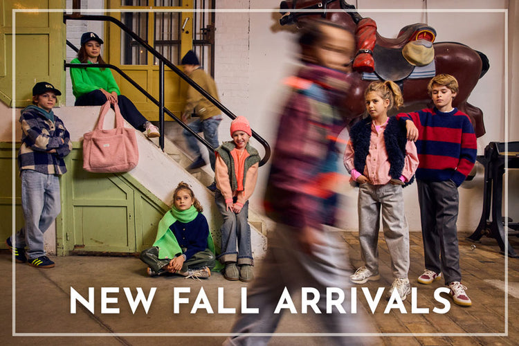 A group of children wearing colorful fall fashion clothing pose on the steps of a building, with a blurred figure walking in the foreground. Large white text at the bottom reads 'NEW FALL ARRIVALS'.